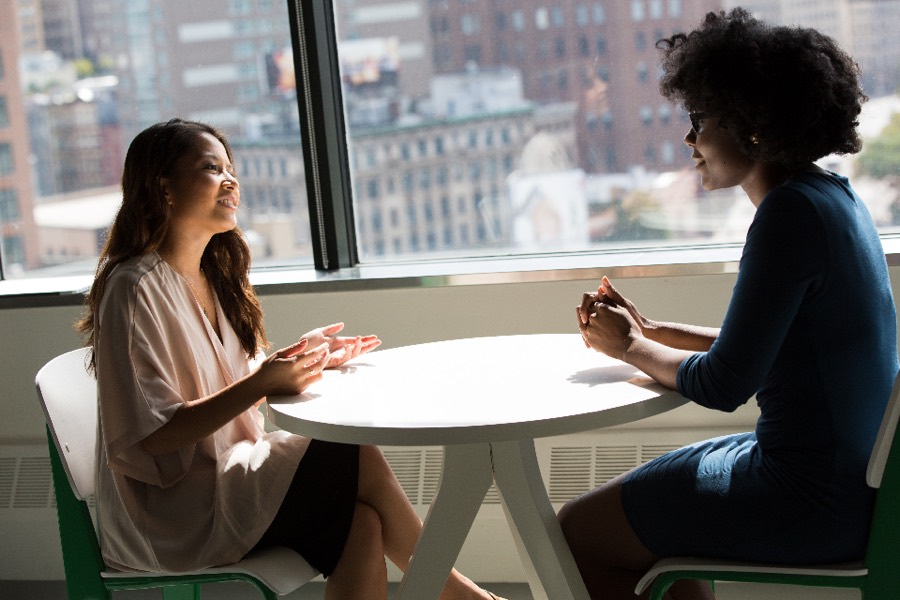Two colleagues talking across a table in a city office