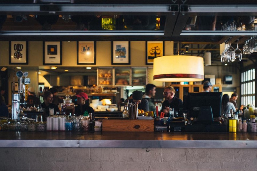 Staff serving guests behind a busy restaurant bar