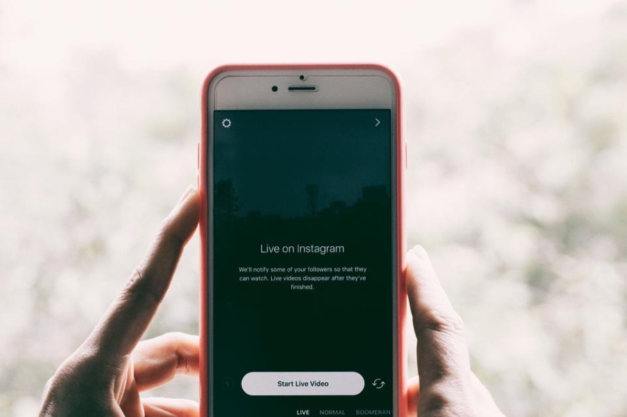 A person holding a phone showing a social media feed